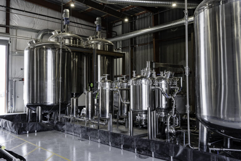 Stainless steel ethanol extraction and distillation equipment inside GVB Biopharma’s cGMP-certified manufacturing facility, showing large mixing tanks and closed-loop processing systems used for cannabinoid production.
